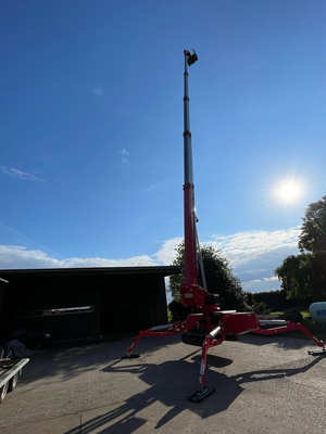 Raupen-Arbeitsbühne im Gegenlicht mit Sonne